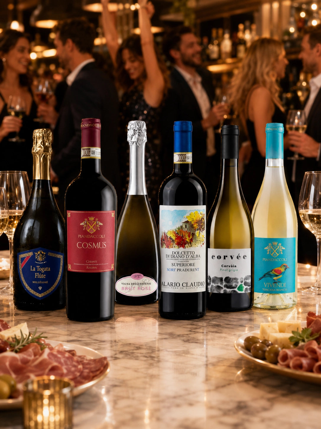 Six Italian wine bottles from Fiorvino’s Perfect Party Box displayed on an elegant bar table with sparkling lights, wine glasses, cold cuts and cheese plates in a festive party setting.