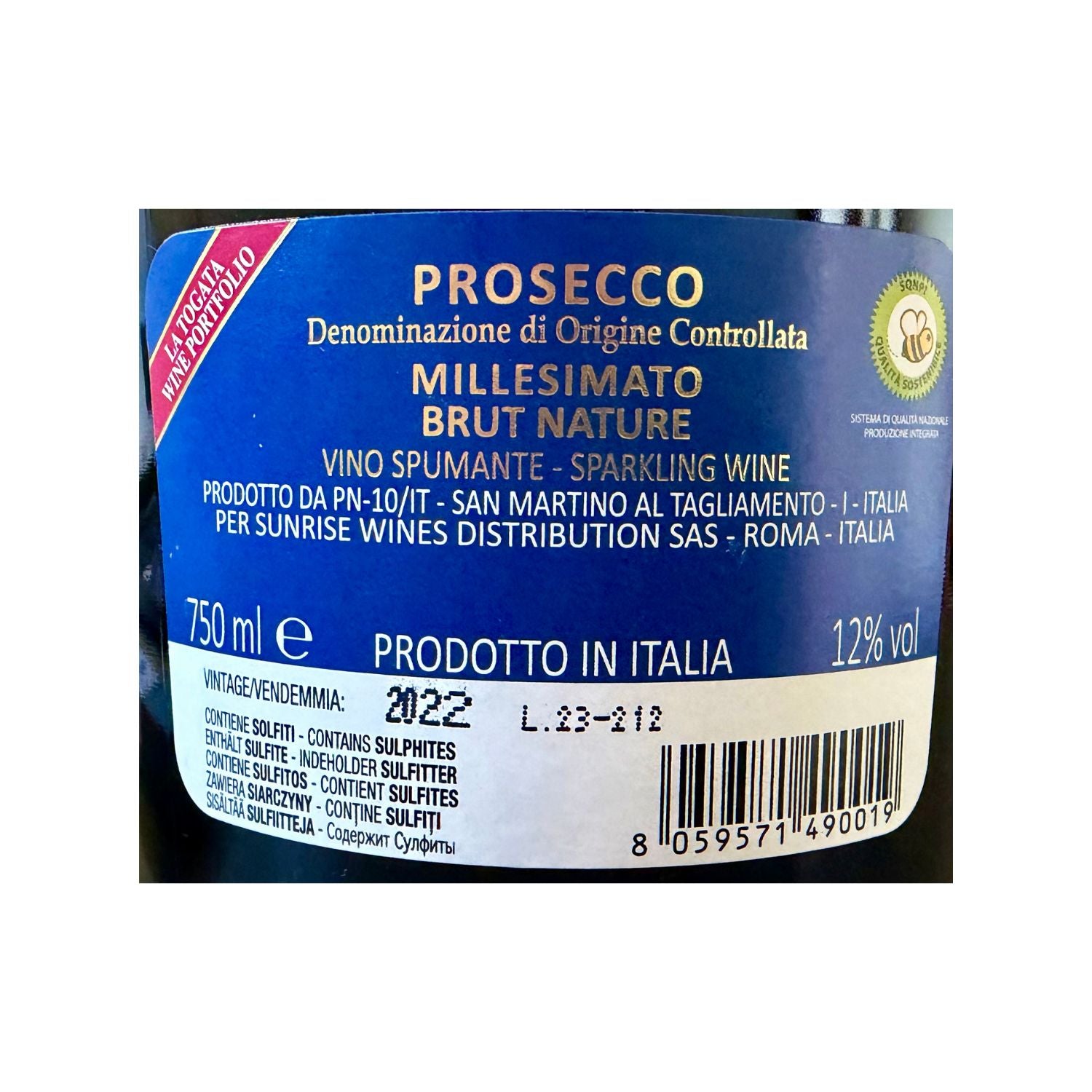 A close-up of a blue wine label for Prosecco, with white and gold text, a red diagonal banner, and a barcode near the bottom. The label reads 'PROSECCO Denominazione di Origine Controllata MILLESIMATO BRUT NATURE' and 'VINO SPUMANTE SPARKLING WINE'.